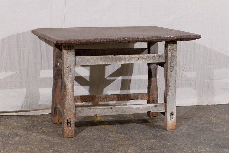 A Swedish early 17th century charming rustic side table with tenon and mortise stretchers. The top is made of stone. The legs are slightly beveled.