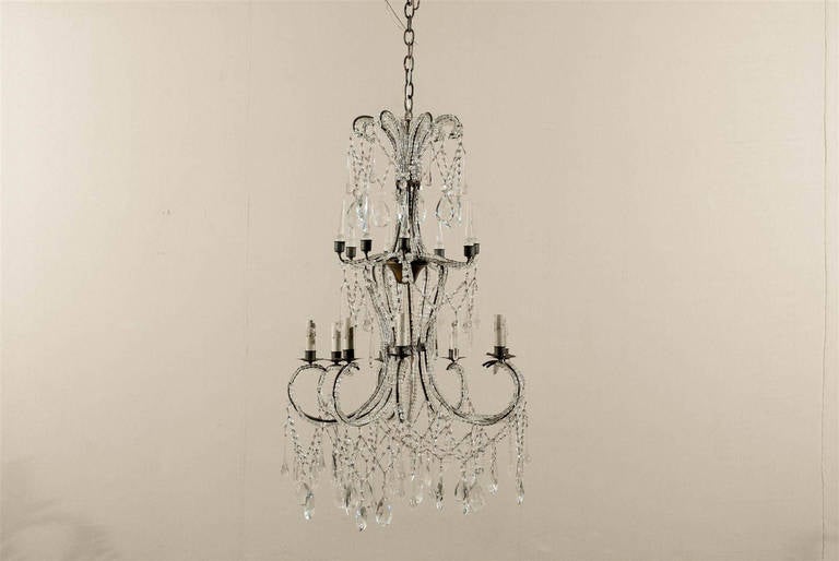 This Italian eight-light crystal chandelier is made of a succession of levels leading your eye down to the dance of crystals happening in its lowest part.  It all starts with the crown from which are hanging a circle of Swedish drops. Your eye now