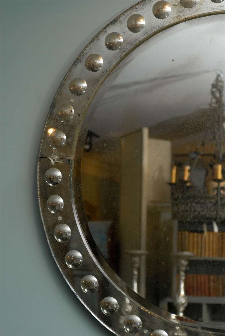 The round Bullseye Venetian style mirror. With its circular shape and assortment of small size bullseye motifs in its surround, as well as star ornaments marking its cardinal points, this Venetian style mirror is the perfect focal point for a living