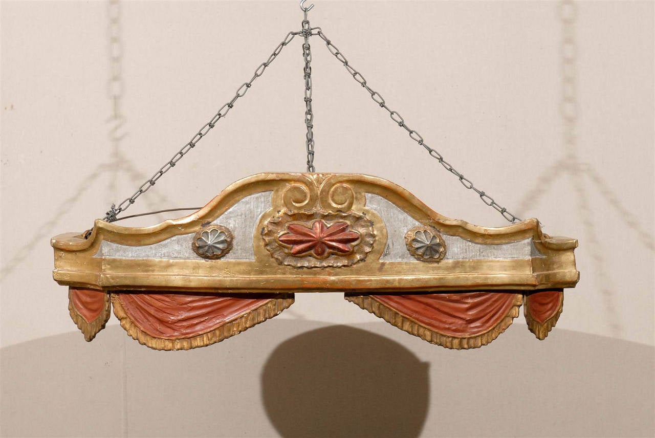 An exquisite 18th century painted and gilded wood Italian bed corona (bed crown).

This Italian bed corona (it means bed crown in English) is the perfect object to decorate your bedroom and hang above your bed. The dominant colors are red, silver
