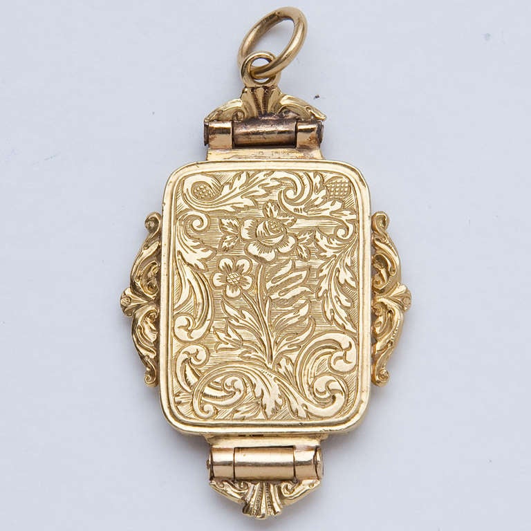 In the form of  a locket, the front and back engraved with florals and scrolls, the grille with bright-cut scroll designs, sides all flanked by extended scroll decoration.  The cover and grille hallmarked with a left-facing Rams head. 12.2 grams.