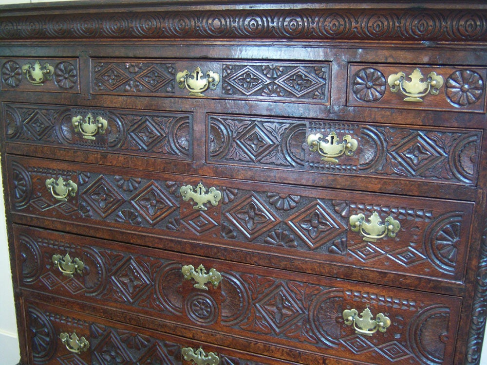 Very rare and unusual English-made for the Spanish market, oak chest on stand, with elaborately carved geometric and floral carvings and original brasses, 11 drawers, with two hidden drawers, all raised on cabriole legs terminating in pad feet.