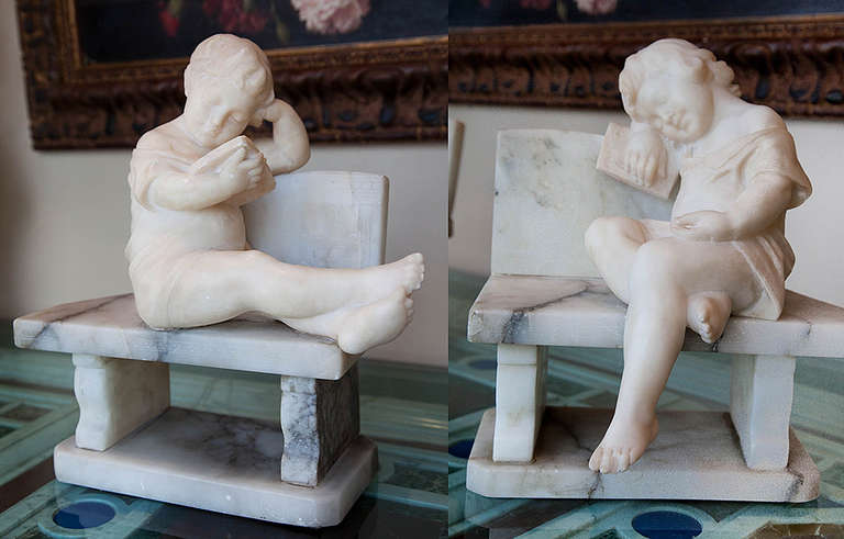 Continental pair of marble sculptured bookends, depicting children, a boy and girl reading books on benches.