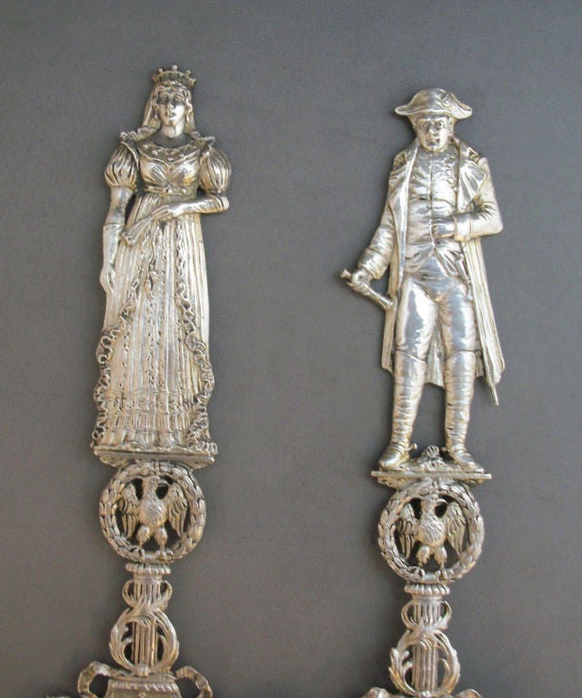 Fabulous pair of German .800 silver servers featuring Napoleon and Josephine.  Napoleon in full attire with a telescope, the crowned Empress Josephine in a gown and gloves holding a closed fan, both standing above open-work eagles centered in laurel