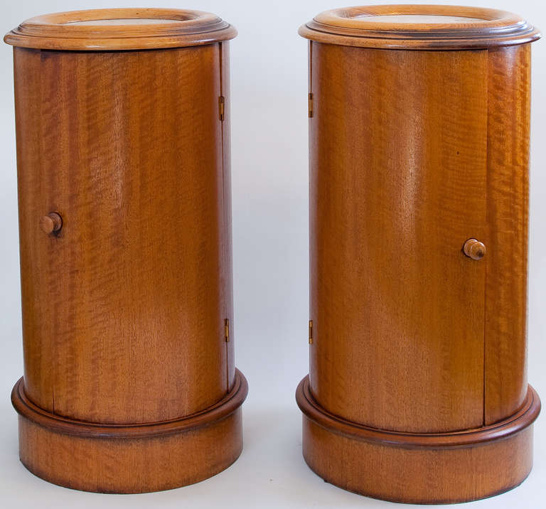 Pair of 19th century Biedermeier side tables, of columnar form, single opening doors, and tops with white marble inserts. 15.5 inches in circumference.