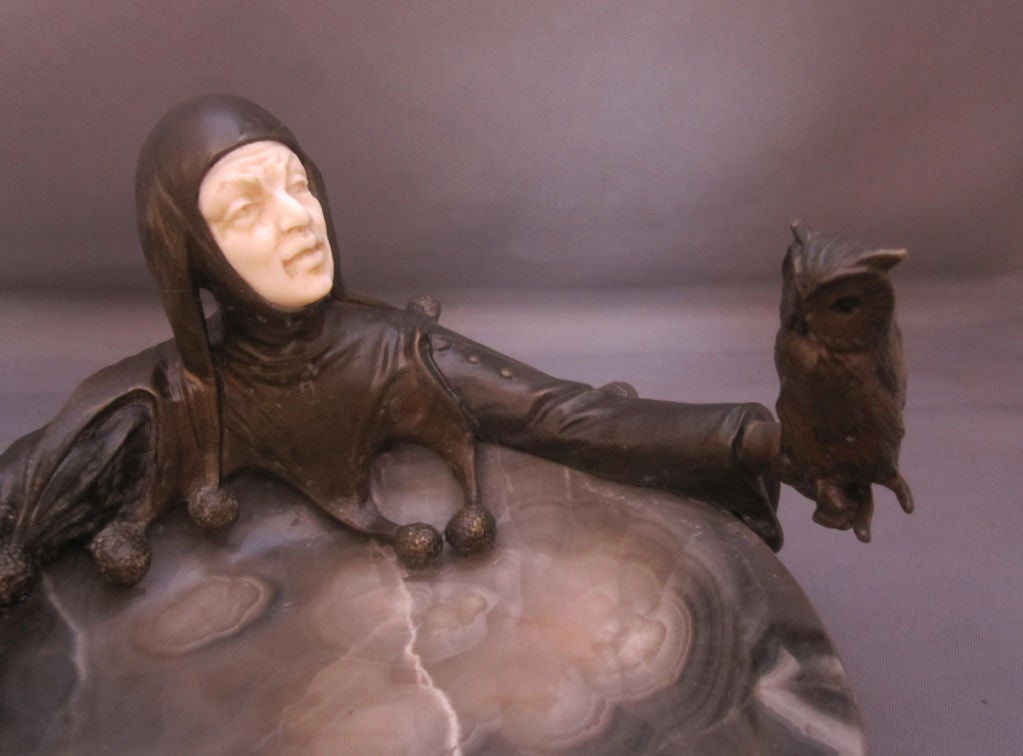Wonderful cold-painted bronze cendrier / pin tray in the form of a jester with a bone face and a perched bronze owl on finger, on a grey onyx dish, the bronze signed A. Titze, Austria.
