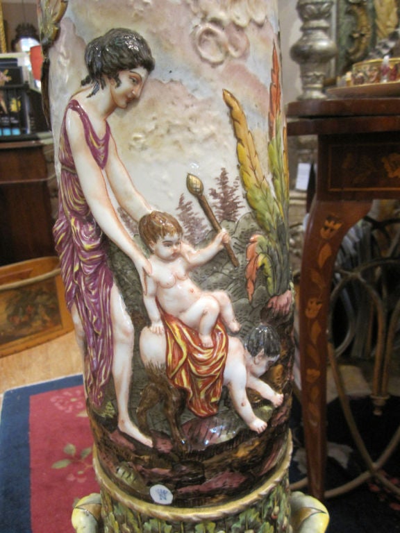 Exquisite Italian signed,Capo de Monte pedestal, the top decorated with flowers, the column with Neo Classical high relief scenes and foliage. The square base with swags flanked by four lion paw feet.  The whole with parcel gilt accenting.