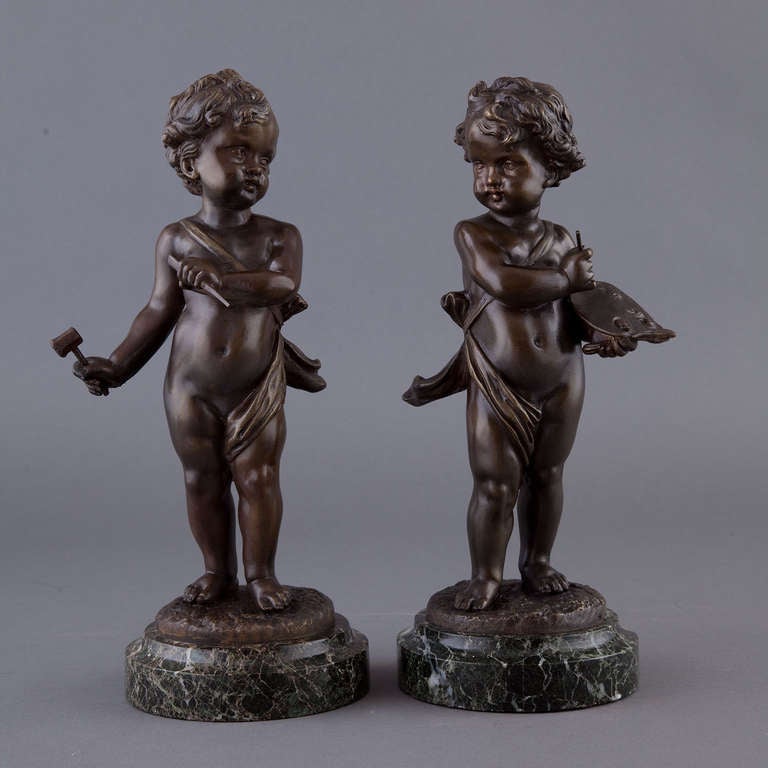 Adorable pair of patenated Bronze putti, one holding an artist's pallet, the other with a hammer, both on marble plinths and signed KAVET.
