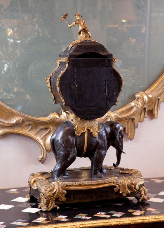 Doré and Patenated bronze Chinoissorie clock depicting a striding elephant holding a clock on his back framed in Bronze Doré with Boulle inlay standing on a Boulle and bronze mounted platform. The clock face is bronze with porcelain Roman numerals