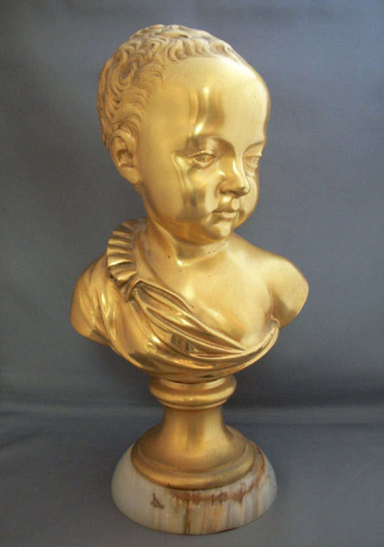 Charming French Empire bronze Doré bust of a child, after a model by Jean-Baptiste Carpeaux mounted on an alabaster base.