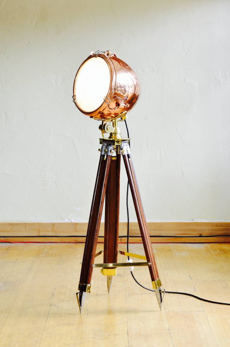 This is a WW2 era polished copper spot light by G.E. We've married it to a vintage wood tripod which is adjustable 50