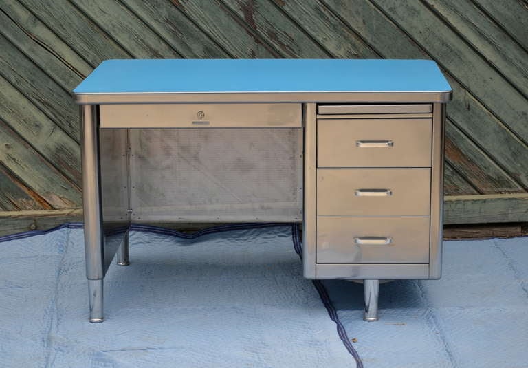 Vintage steel tanker desk by Steelcase, USA. Heavy gauge steel, thats been stripped, hand polished and clear coated. Key locks the center pencil drawer and the top side drawer. New Formica top, this one is medium gray, though colors are