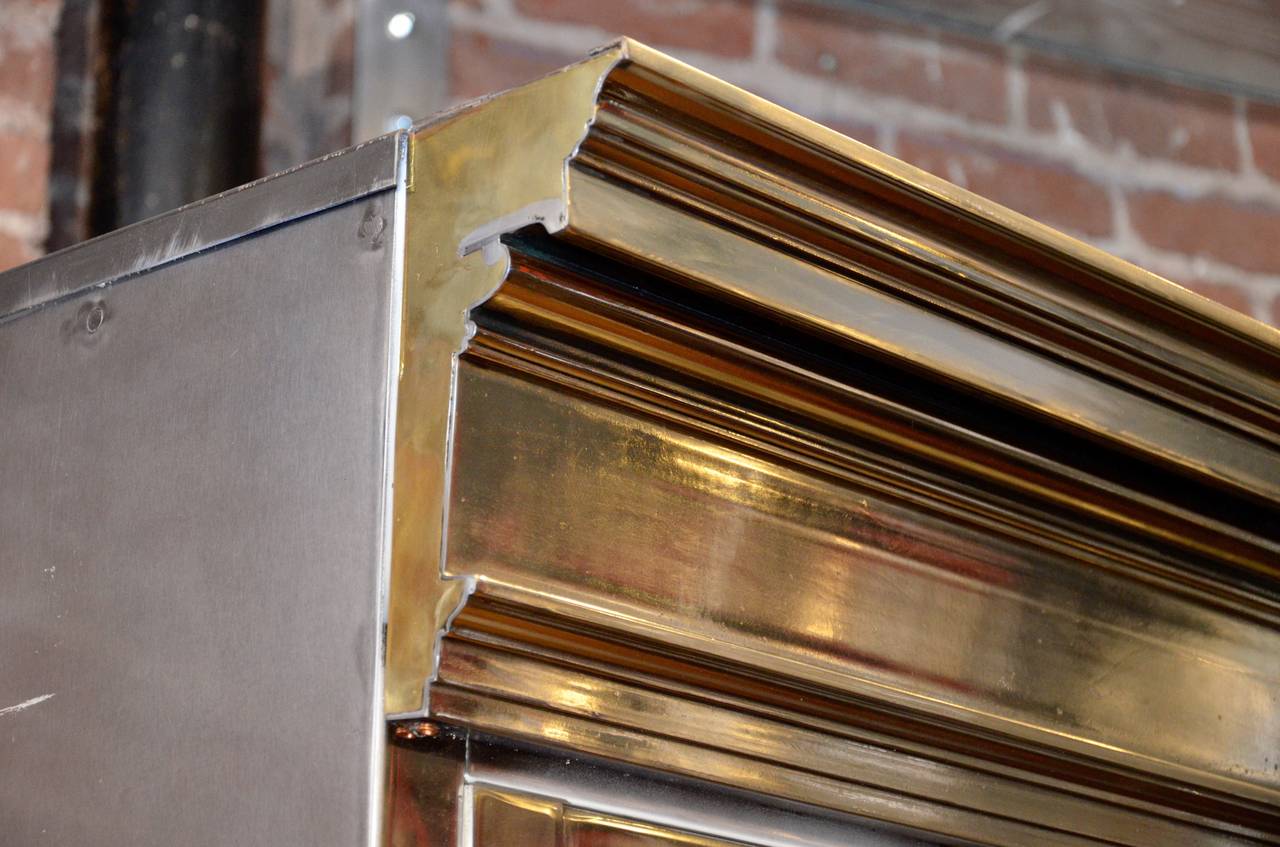*This item is eligible for FREE domestic shipping through December. Please contact Polished Modern for details.* Rare and amazing polished steel lockdown cabinet. Beautifully styled with a Georgian cornice, and brass handles. This was a