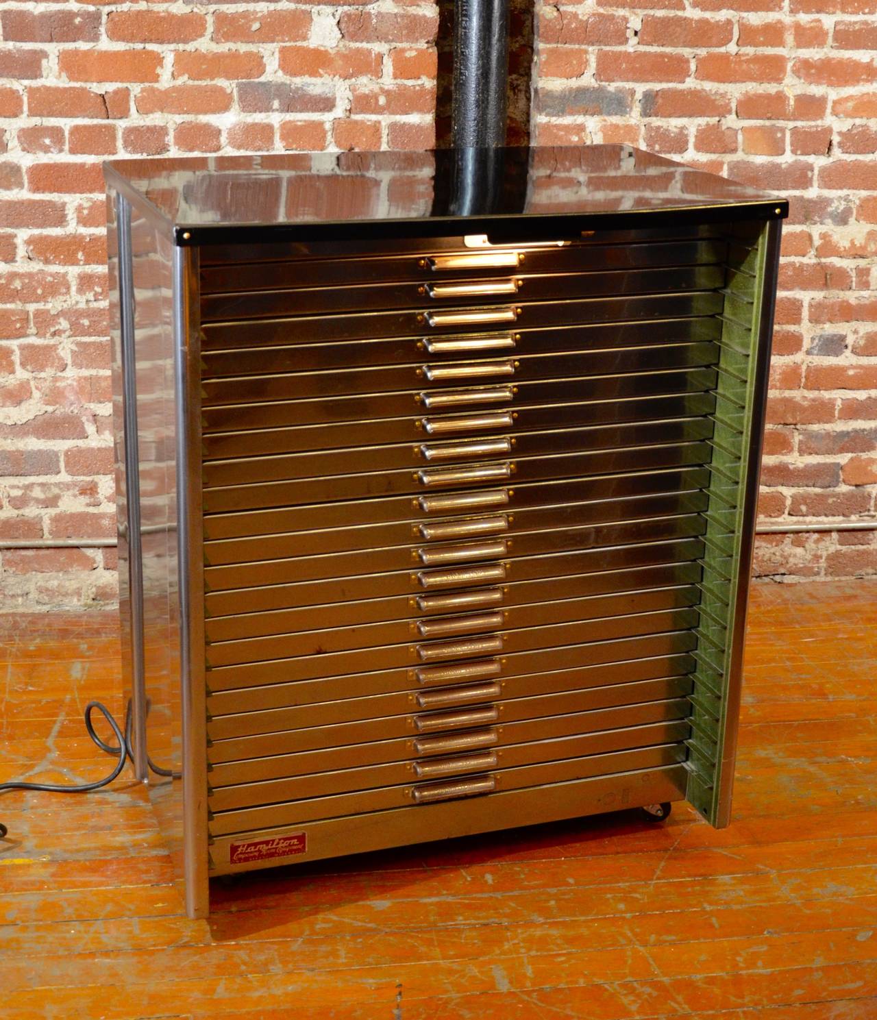 *This item is eligible for FREE domestic shipping through December. Please contact Polished Modern for details.* Handsome polished steel printers cabinet by Hamiton Composing Room Equipment. The cabinet drawers are partitioned into neat little