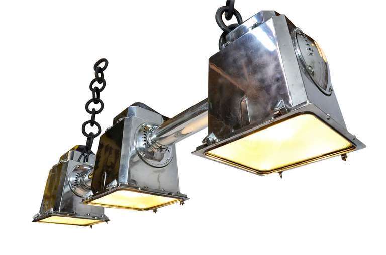 Polished metal chandelier with hardcore iron chains. These fixtures were designed for 3M in 1969. We've customized this for use as billiard lighting or for a variety of home or retail applications. These are retrofitted with standrd size porcelain