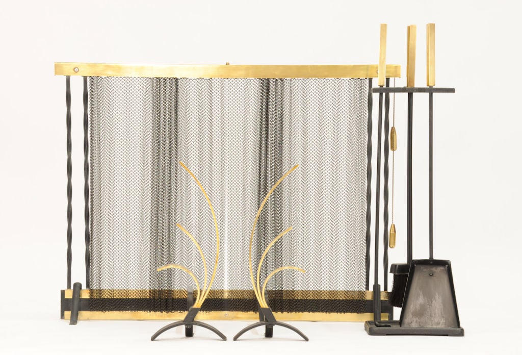 Handsome set to dress the fireplace.  This Deskey style ensamble features retractable mesh screen, plume themed fire dogs, and tool caddy with poker, brush, and ash scoop. All constructed of iron and brass.