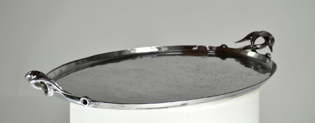 Handsome oval serving tray made of hammered aluminum. Striking fish hook handles.
