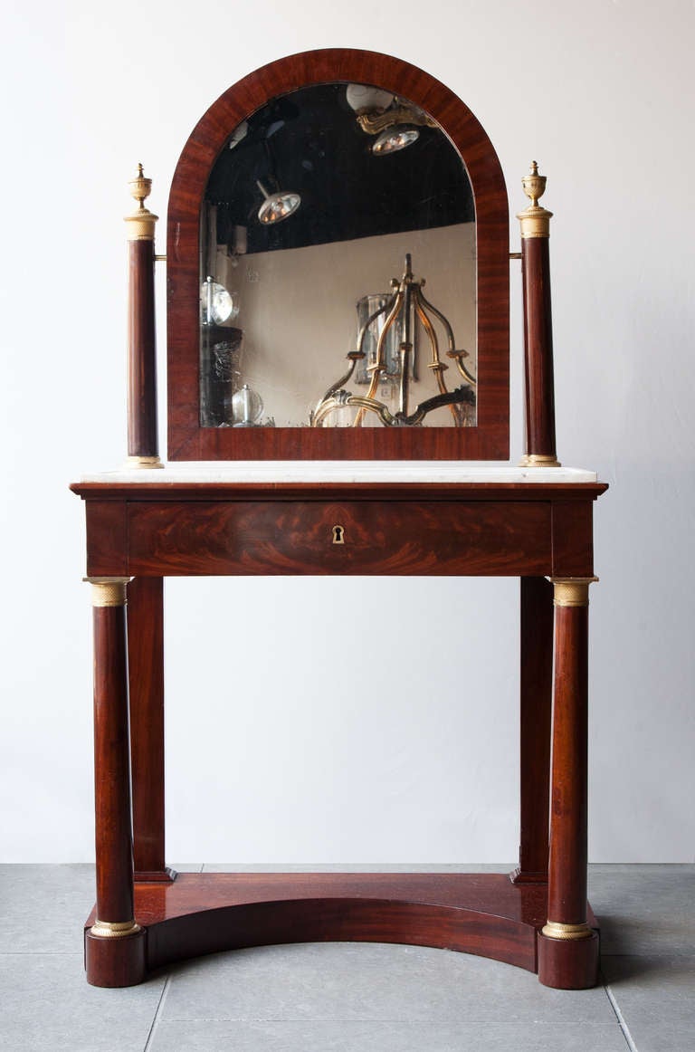 Table de toilette à psyché. Empire period mahogany dressing table with original tilting mercury mirror and white veined marble. One central drawer with lock (no key) and finely incised gilt bronze mounts.