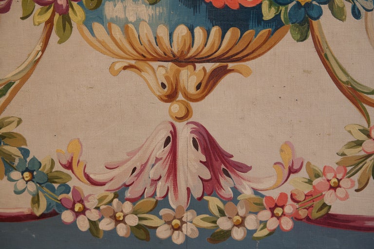 Aubusson Tapestry Cartoon for a small sofa seat in the late 18th century French Director style. Flowers and arabesques in pinks and blues with a central urn blue. Oil on Canvas on stretcher. Fully restored. Framed in a hand a hand made frame with a