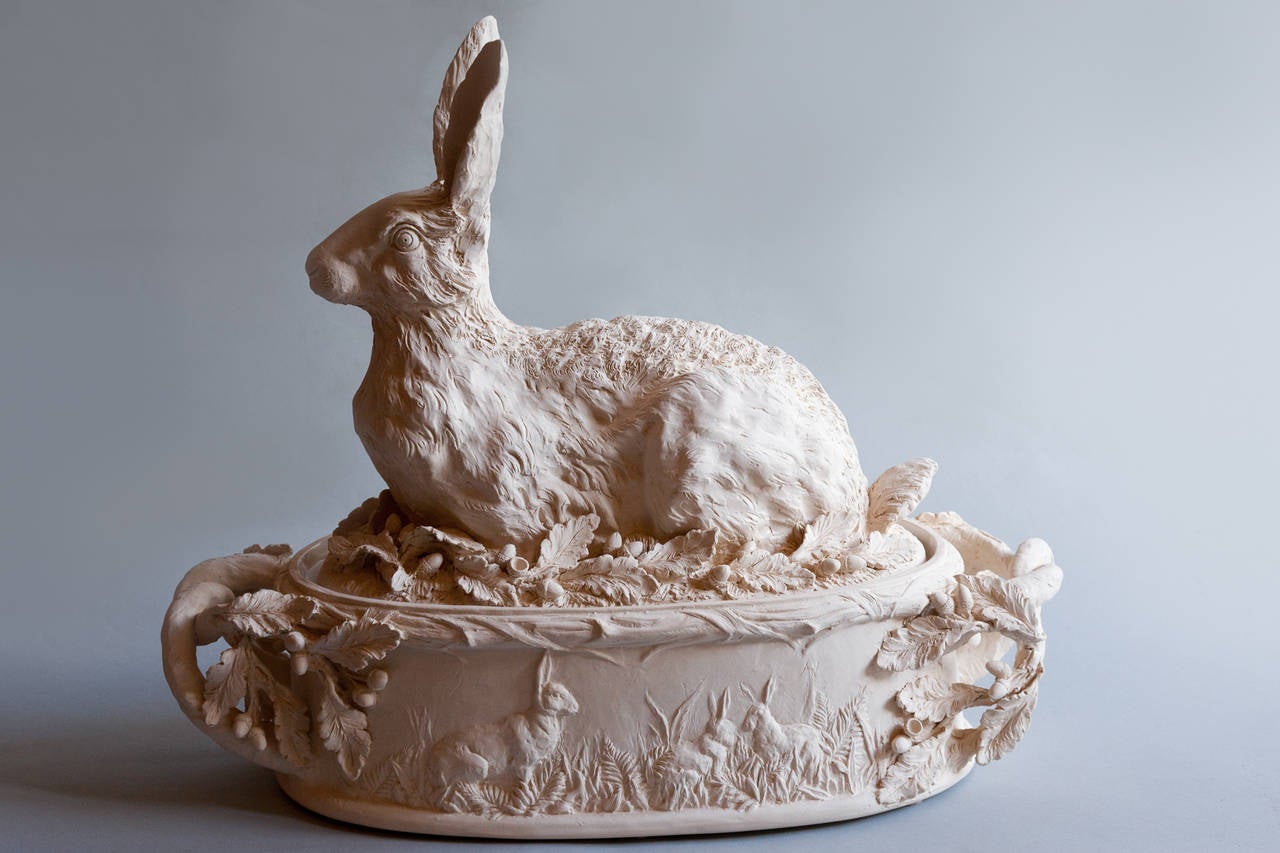 With oak leaves and acorns. The top lifts off to reveal the inside which is glazed.