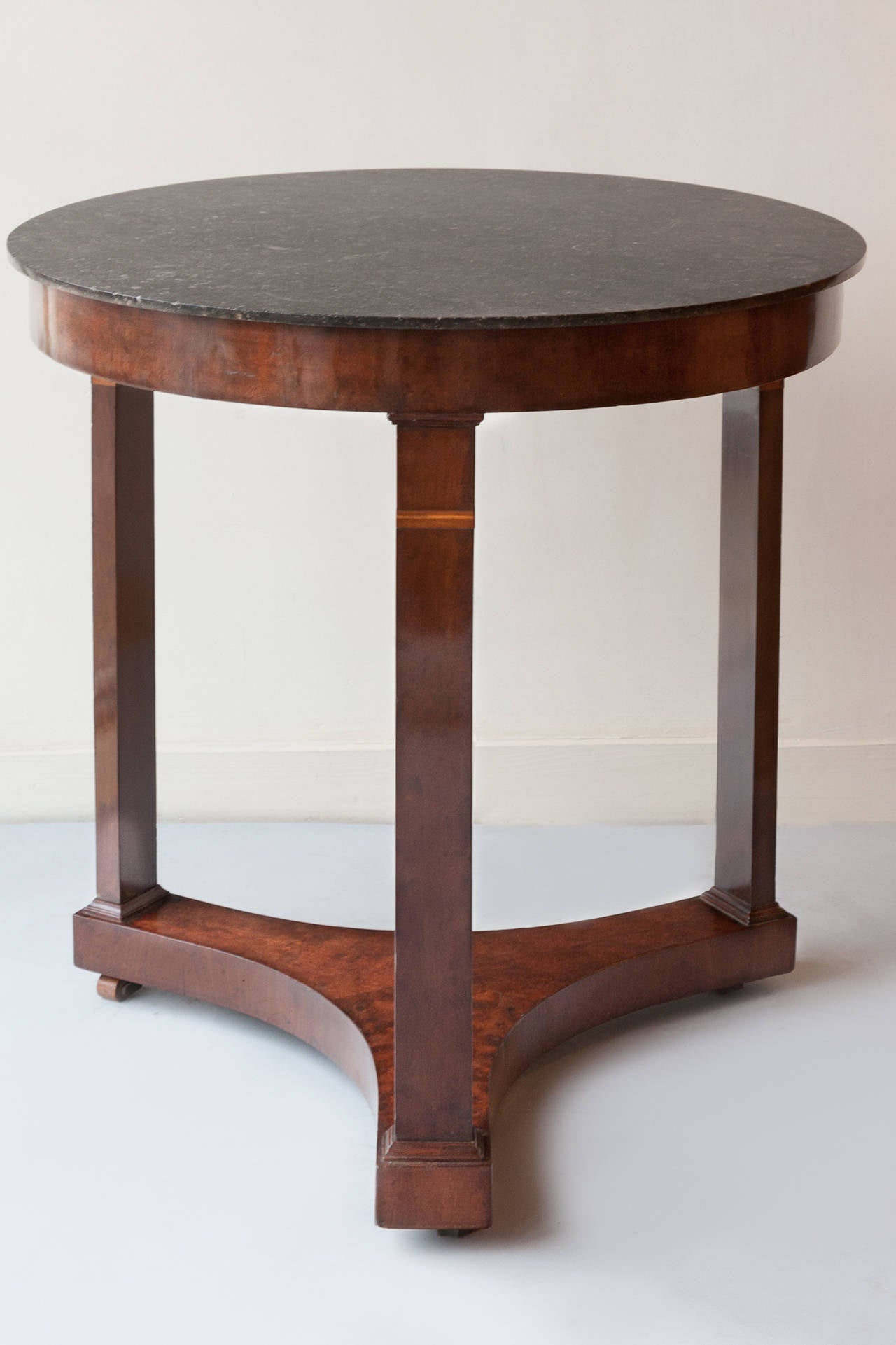 Plumb pudding mahovany with black marble top. Small inlaid bands of boxwood on the flat rectangular legs. 
The marble has had a small repair to the side.