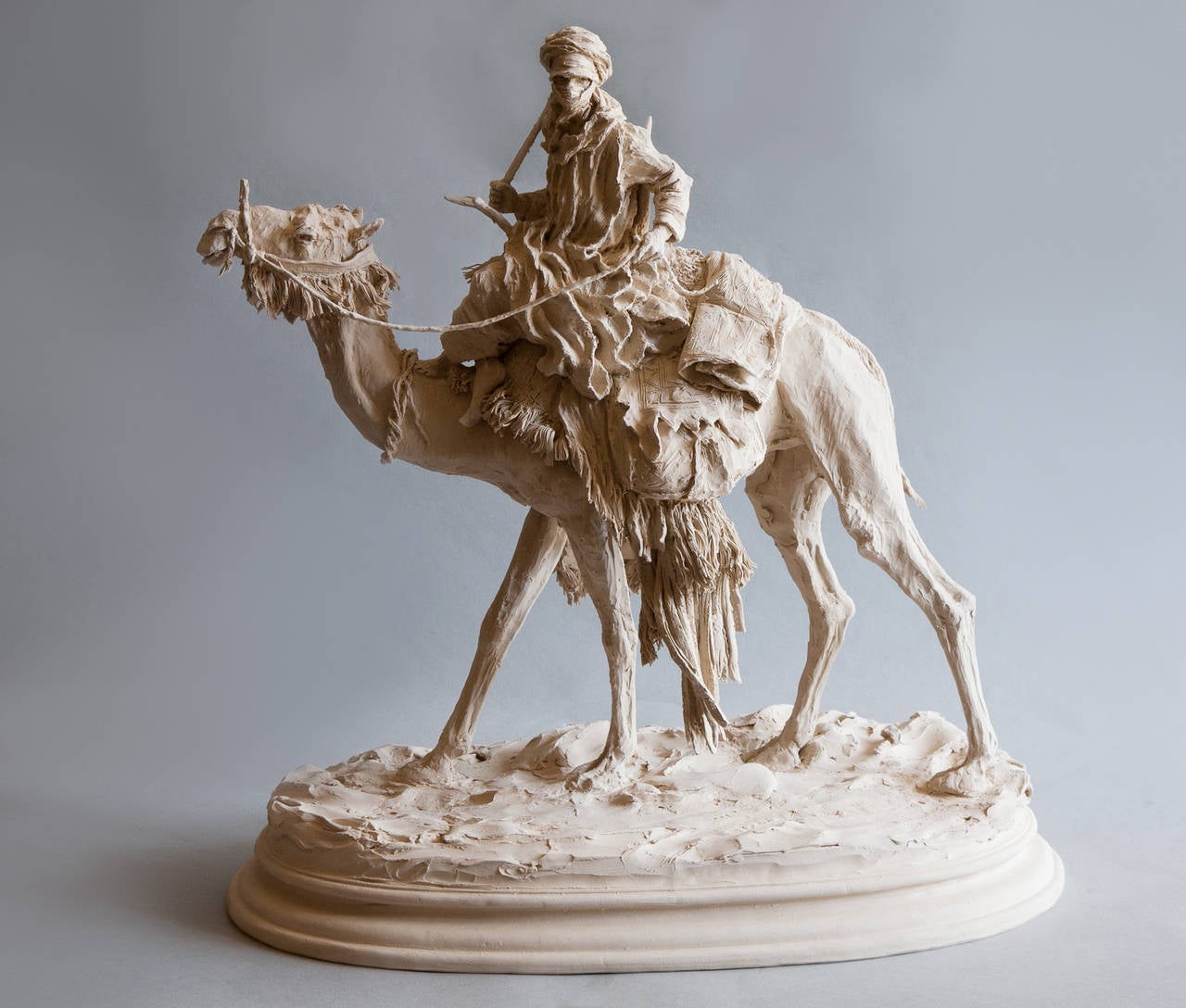 Contemporary sculpture in grès porcelain by Jean Paul Gourdon (b. 1956)
The dromedary is richly adorned with fringing, saddle bags etc; seated on top is the figure of a Tuareg in traditional robes and turban. He has the reins in one hand and a