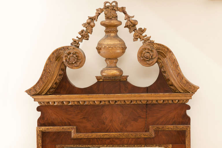 Walnut veneer and a shaped egg and dart border with applied foliate pendants to each side. Surmounted by parcel gilt pediment. The gilding and walnut veneer in untouched condition. English early 18th century, in original country house condition.