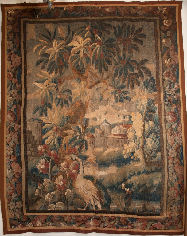 Verdure tapestry with an exotic wading bird in the foreground, chateau in the background. surrounded by a decorative floral border. Reduced in size circa 1750.
Decorative in the classic Aubusson style.

Browns, blues, greens and reds.