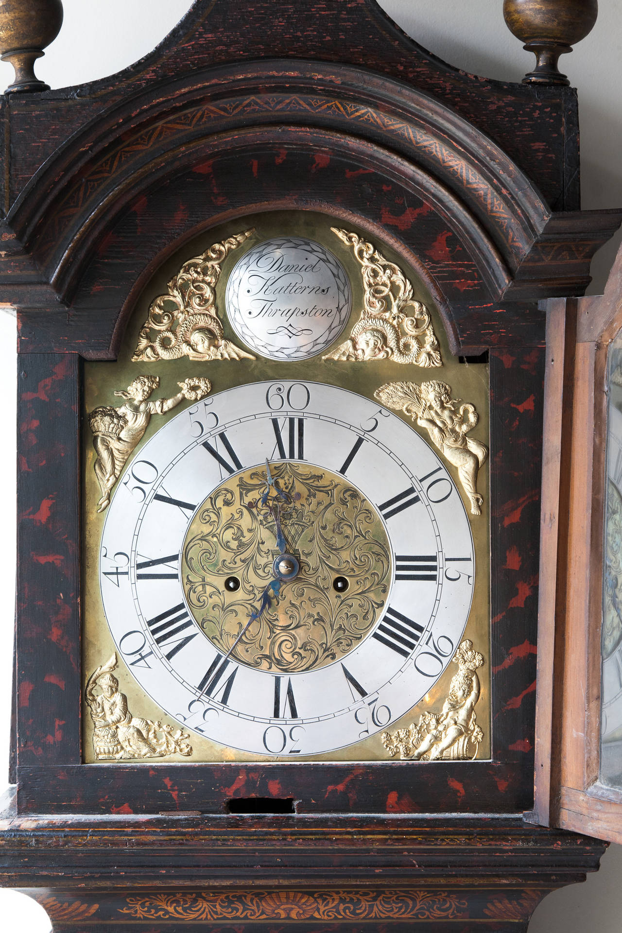 A George III Black lacquer cased eight day grandfather clock. 
The brass broken arch dial plate with applied chapter ring and four season spandrels, the convex boss bearing the legend 'Daniel Katterns Thrapston' (Northamptonshire), the hood with