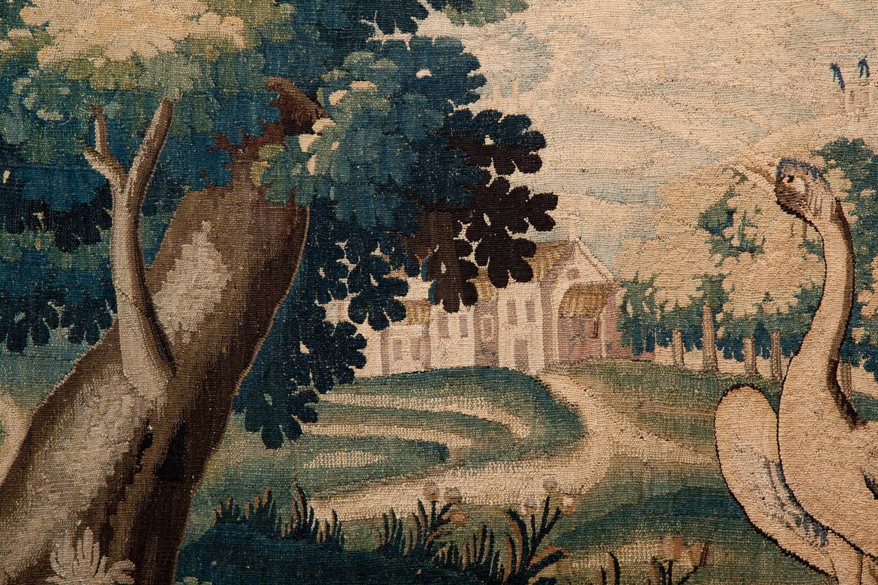 With a white heron in a wooded landscape with buildings in the background and a castle on a hill.
Surrounded by a decorative border of flowers and birds. Woven in wool. France c. 1760. 

The tapestry is in good condition it has been cleaned and