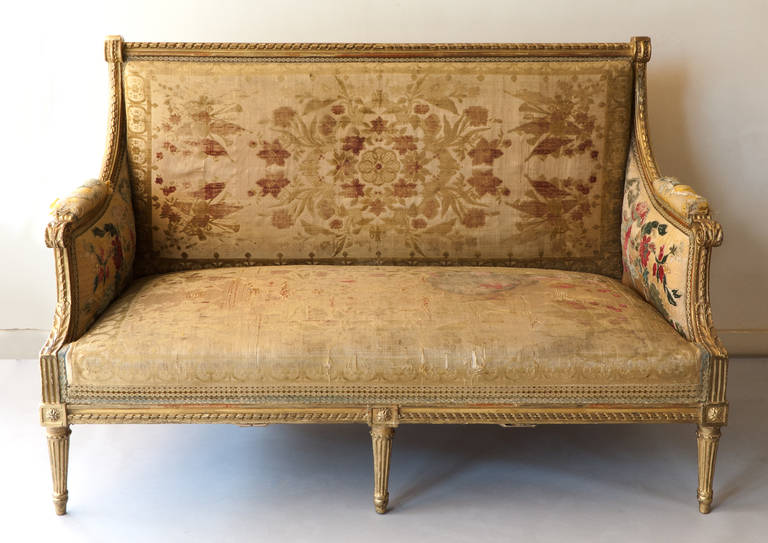 The rectangular back surmounted by a turning ribbon, also extending down the arms and front apron and meeting upwards facing acanthus leaves.
Supported on six fluted legs with solid upholstered arms and upholstered seat. Original silk velvet
