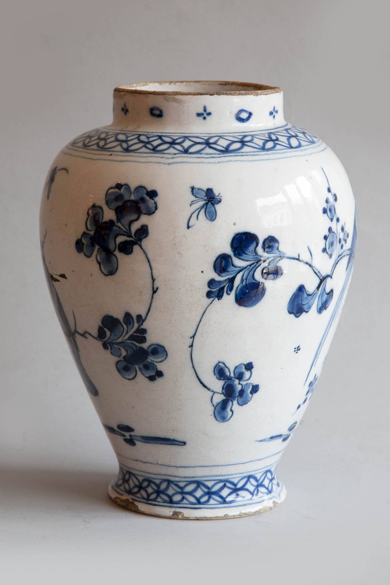 Decorated with birds, flowers and leafy branches in blue and white on a milky white background.
Some chips and old repairs, but in good condition for its age. See photographs for details. This vase is a close pair in size, period and shape to