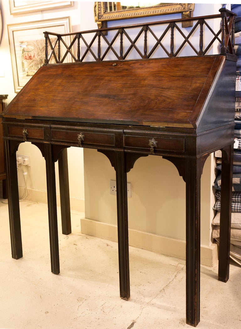 Mahogany desk standing on six legs the two centre legs turn outwards to support the front when lowered. Orginal brass handles
on dummy drawers acrss the front. Opened there are six satin birch drawers with ebonised escutcheons. 
The piece is in