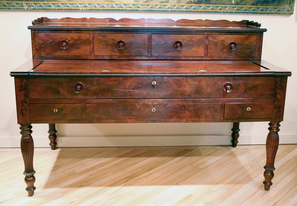 Large French Restauration period desk, mahogany and flame mahogany veneer over oak. Polished on all sides. The upper part has four drawers with wooden recessed knobs. This upper part lifts off for transportation. The lower part has two smaller and