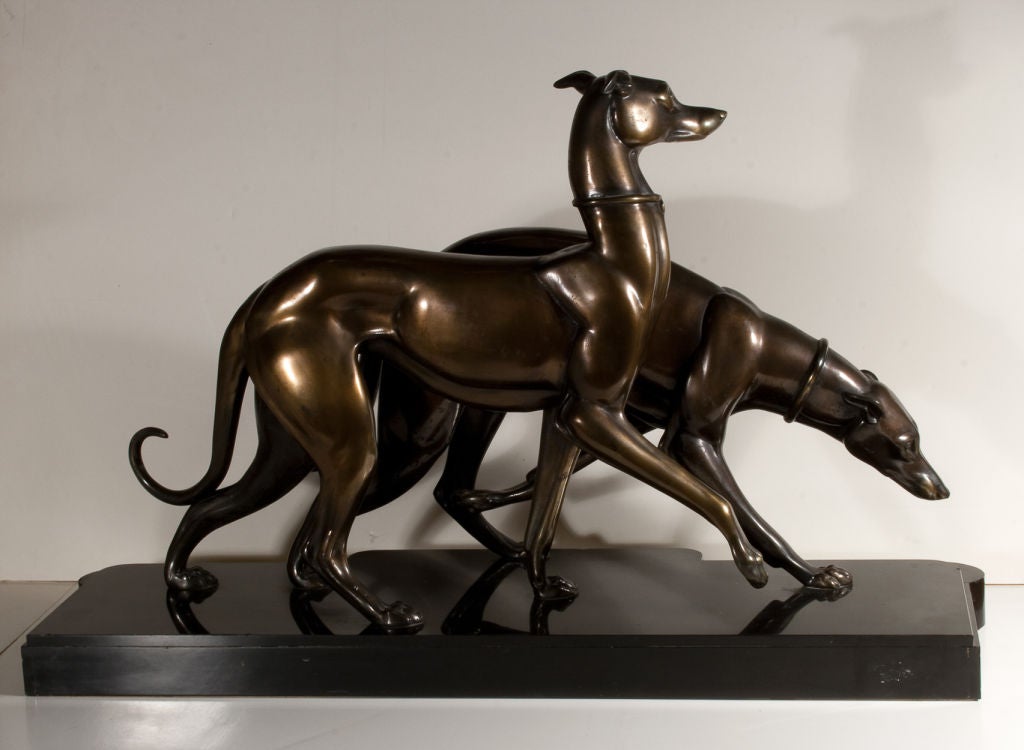Pair of large scale statues of whippets or Italian greyhounds. Régule, or speltre patinated in a bronze finish, on a black marble and veined beige onyx base. Signed on the base ROCHAS. This large and typically Deco statue of dogs is by the renowned