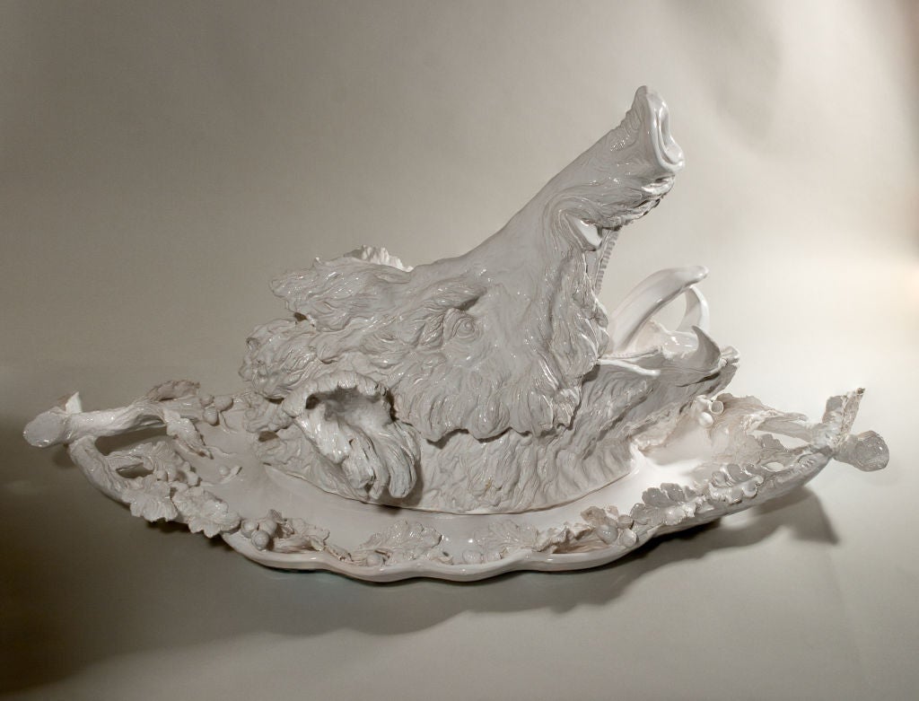 Large white glazed faience wild boar's head tureen on large decorative platter. By Jean Paul Gourdon. This monumental piece is inspired by 18th century designs, the head lifts off to reveal the interior of the terrine. The head and base then lift