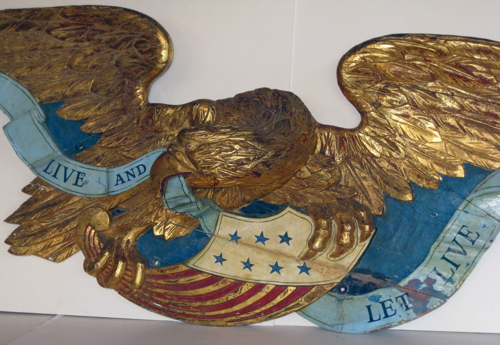 Large carved pine and gold gilt Eagle having a painted banner reading Live and Let Live.  Massachusetts probably Boston. The<br />
gilding in photo # 7 is the closest the true color.