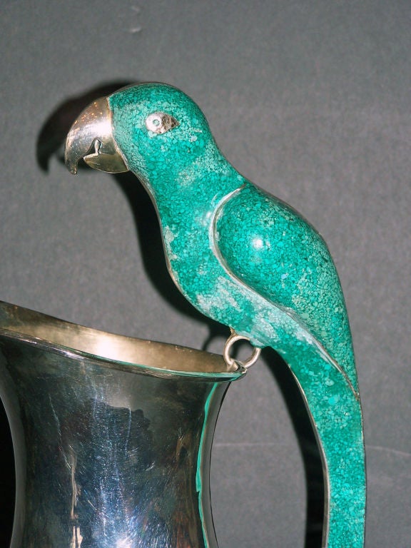 Silver pitcher with a malachite parrot handle.  It look to be Mexican, but we can not read the stamp on the bottom.