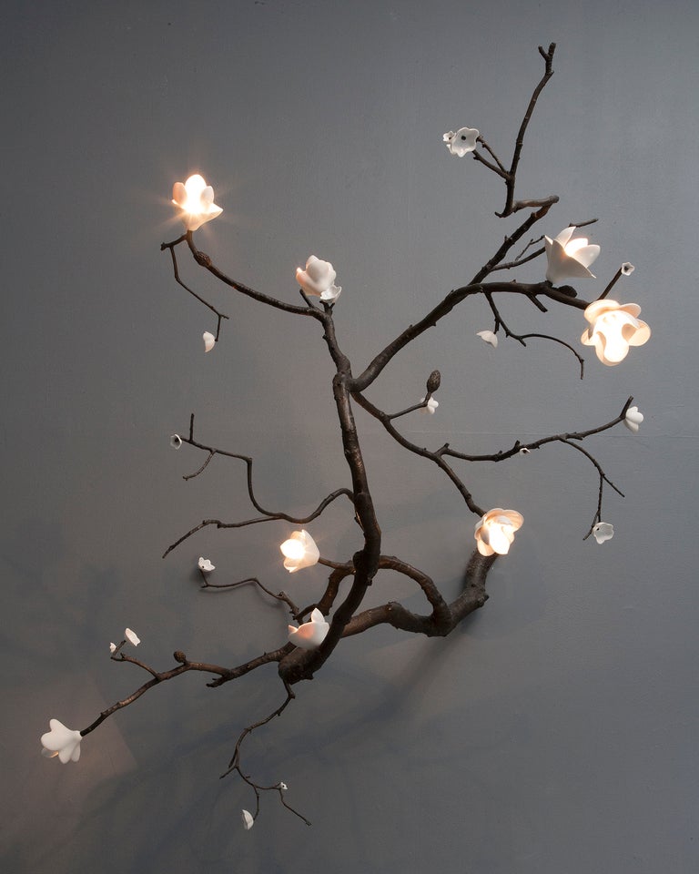 Unique large wall mounted Branch illuminated sculpture in bronze with white porcelain blossoms. Designed and made by David Wiseman, USA, 2012.