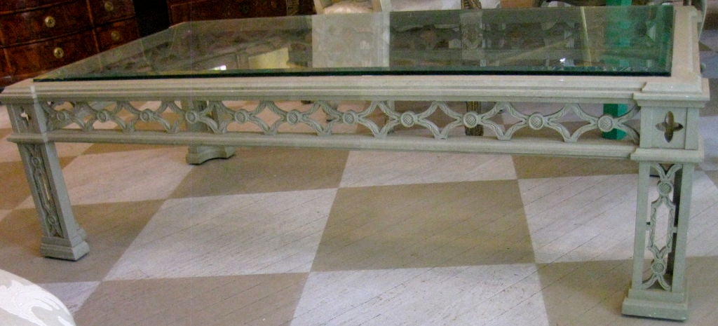 English painted carved wood and glass cocktail table.