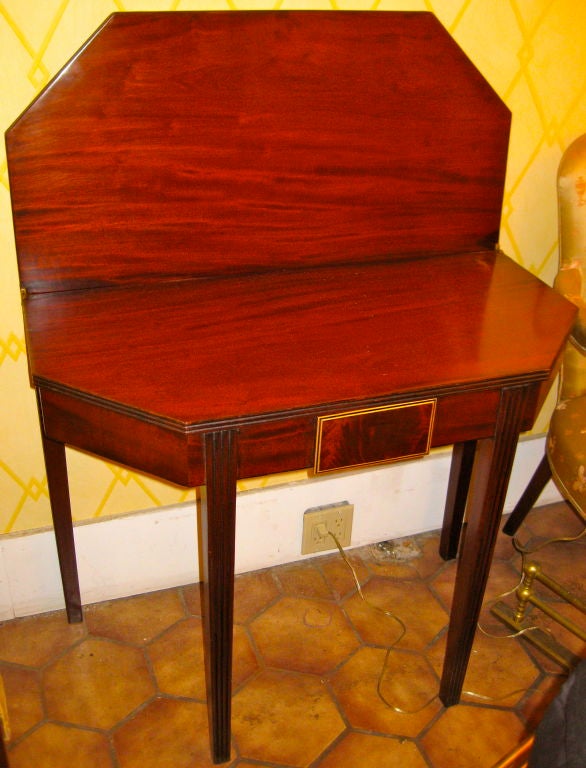 Englischer Mahagoni-Kartentisch aus dem 19.

mit zwei ausschwenkbaren Hinterbeinen 

zur Unterstützung des gefalteten Eckverdecks. 

Eine Schublade in der Vorderseite mit satinierter Holzverkleidung.