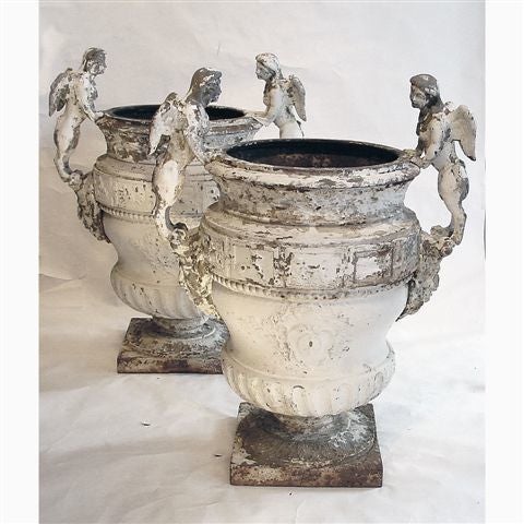 Cast after the design of Claude Ballin for Versailles, each having leaf decorations to the rims over a band of Zodiac reliefs, the main body with wrythen flutes on a spreading socle with leaf pattern on a square plinth.   The bodies mounted with