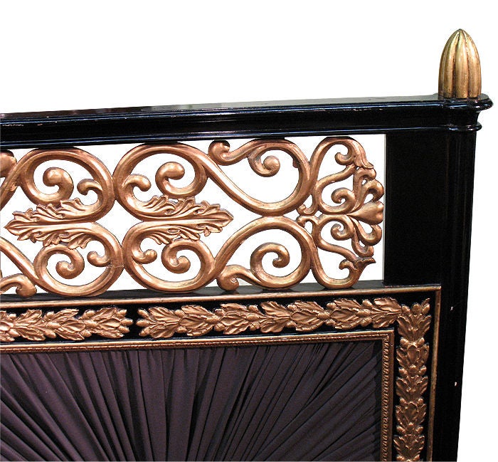 Magnificently gilt wood decorated ebonized Neo-Classical fire-screen. Pierced scroll foliage top with acorn finials. Fabric panel, sunburst bleeded. Frame with moldings (branches with blossoms and stiff-leaf motifs). Splayed legs with palmettes and