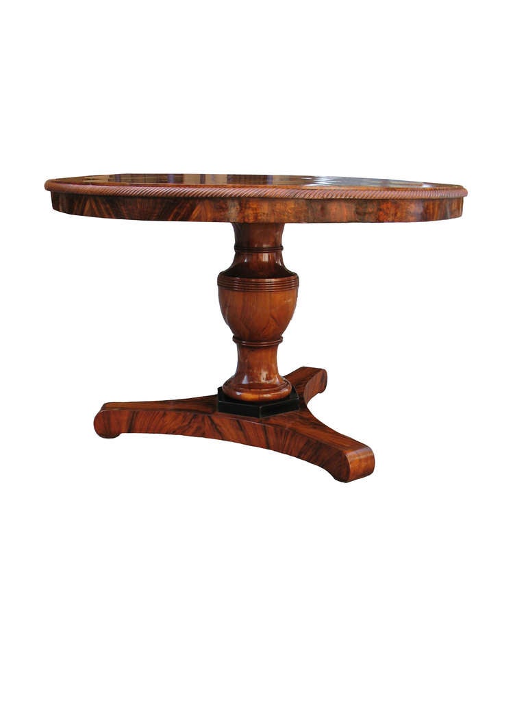 The table-top couldn't have been better veneered. Multiple enlarging hexagonal starts forming six times repeating pattern (for dining, to serve six people). Fluted molding. Urn-shaped pedestal over ebonized plinth on tripartite book-match