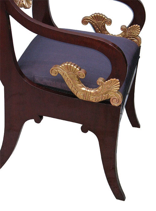 Mahogany veneered on pine, shoulderboards in bookmatch pattern. Finely detailed giltwood carvings. Scrolled arms. Padded seats. Raised on sabre legs. <br />
<br />
Reference: pages 208 and 211, A. Cheneviere 