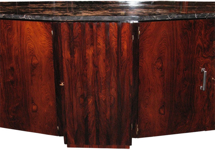oversized, extraordinarily designed and detailed elegant French Art Deco buffet. Rosewood bookmatch veneered on mahogany. Angled sides, each with two doors enclosing a shelf. Original patinated handles, original Pasquille locks. Fluted center door