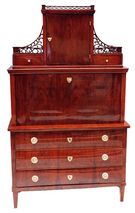 Lower part with three drawers. Center part with a fall front and a seven-drawer fitted interior surrounding a niche. Stepped upper part with a door, two drawers and a beautiful, pierced balustrade. Veneered with stained maple, interior with