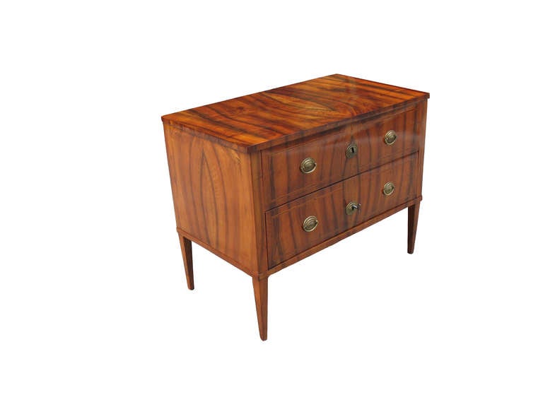 Two-drawer cubical body on long square-tapered legs. Veneered with highly-figured walnut on pinewood in book-match pattern on all four sides. The standing veneers from the 