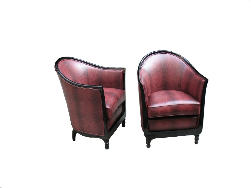 A pair of comfortable French Art Deco bergeres. Ebonized wood frames with barrel-backs, down swept arms, lyre-like shaped fronts over turned feet with three balls. Reupholstered from frame up with webbing, coil springs, horsehair, loose cushions.