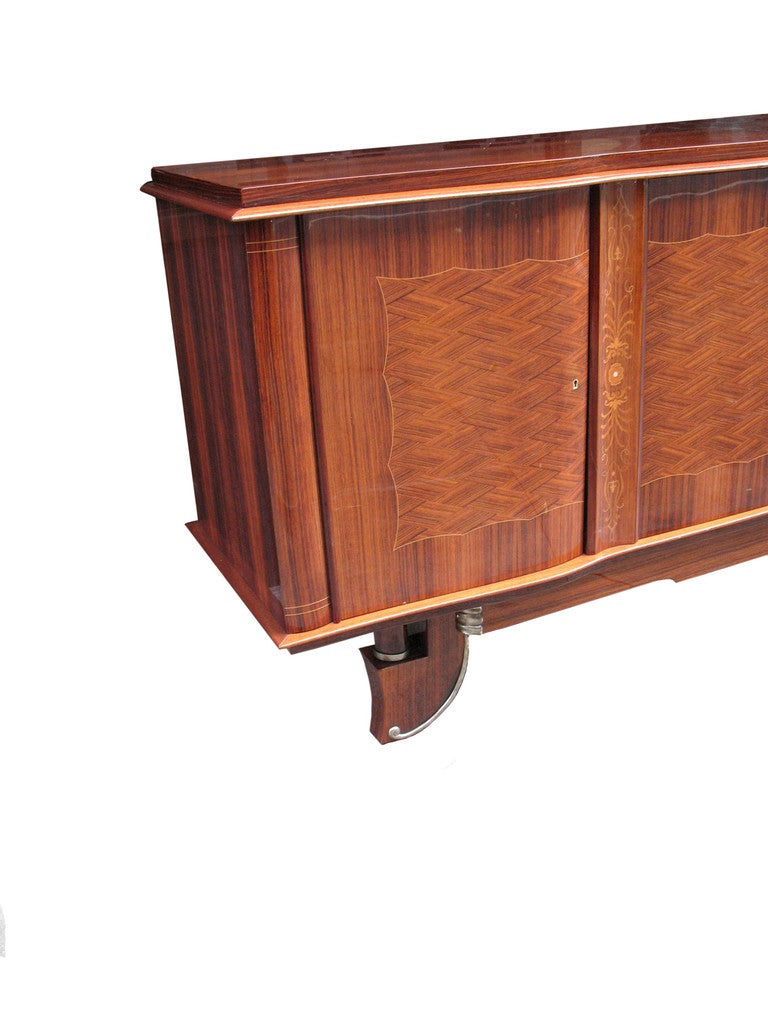 This large, magnificently detailed Jules Leleu inspired French Art Deco marquetry buffet with rosewood in diamond pattern is inlaid with palmettes and hairlines in satinwood. Raised on a platform with chromium-plated trim in center and on feet with
